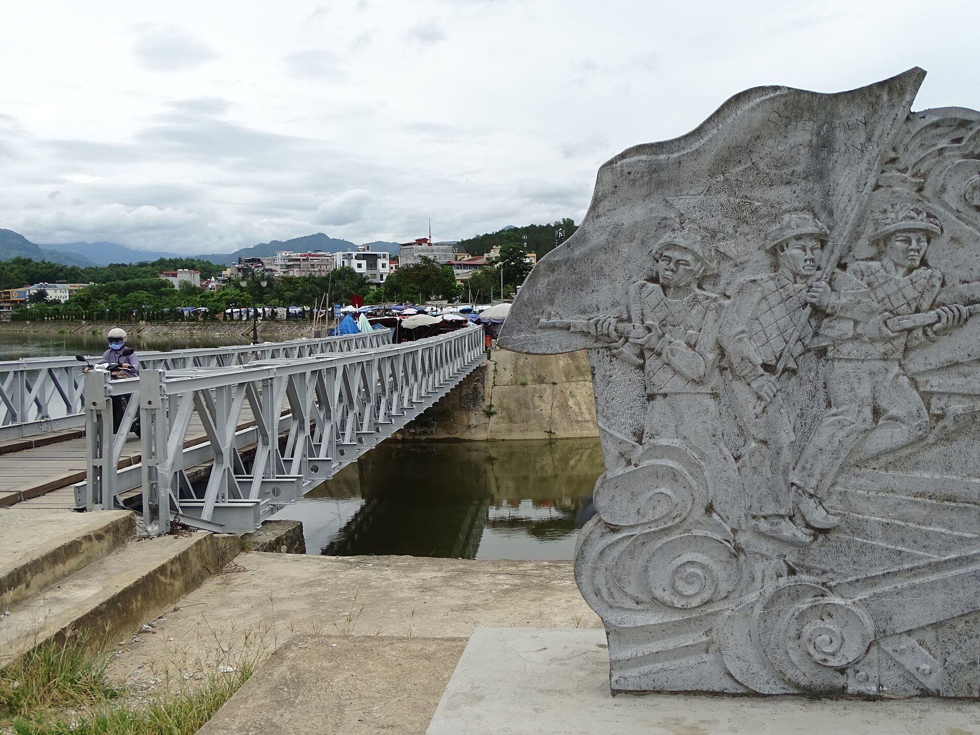 Cầu Mường Thanh nhìn cùng phù điêu tưởng niệm gần cầu.