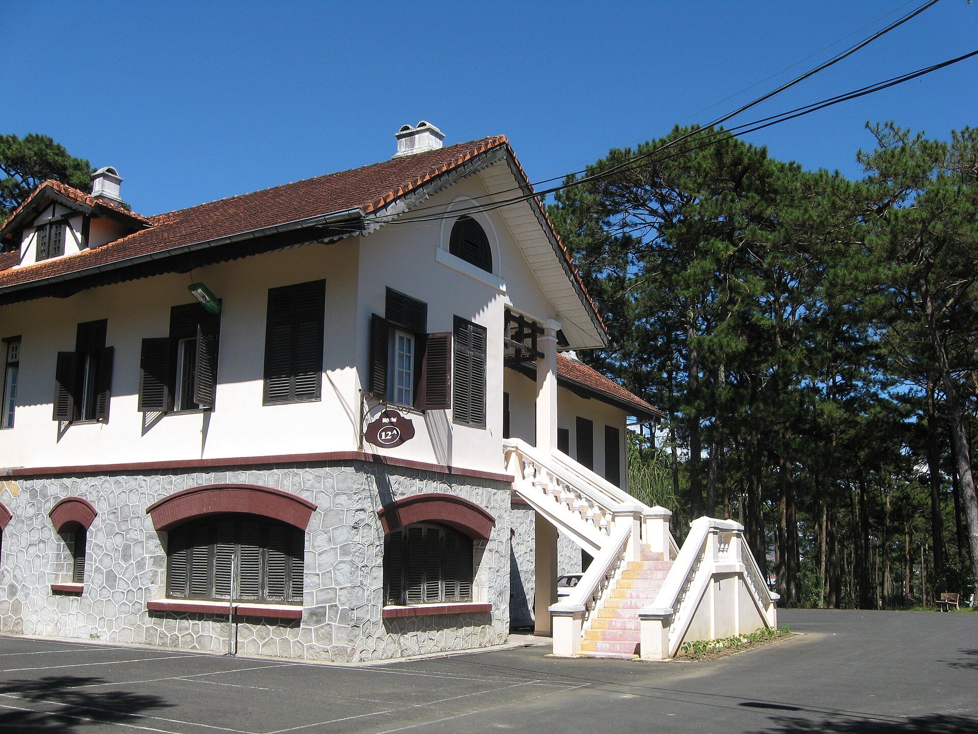Villa 12B trong khu Dinh II Bảo Đại Đà Lạt giữa hàng cây.