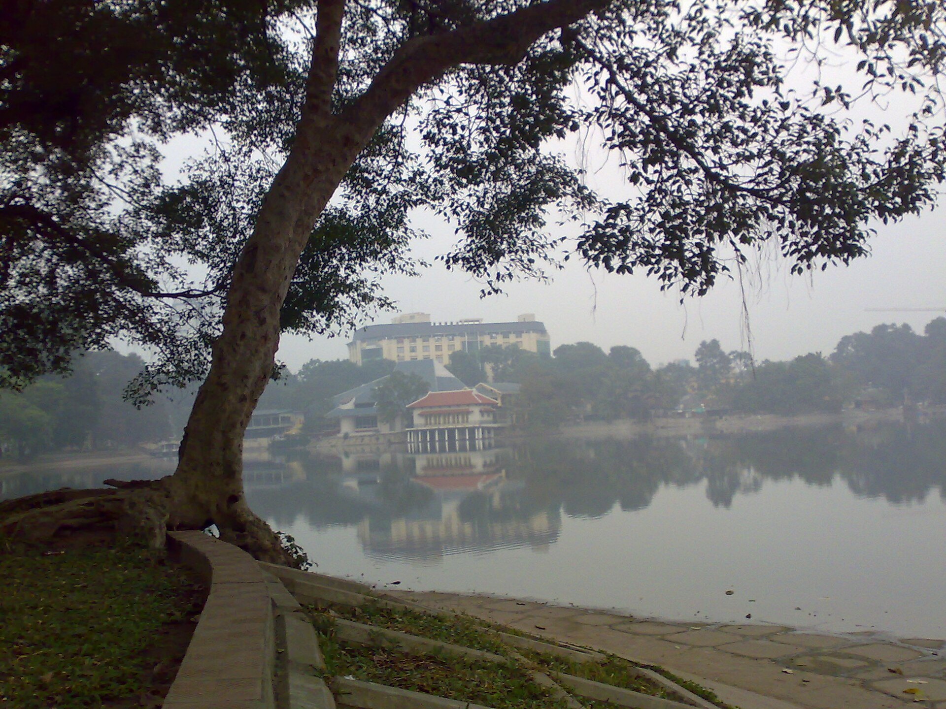 Hồ Thiền Quang nhìn qua hàng cây và mặt nước lặng.