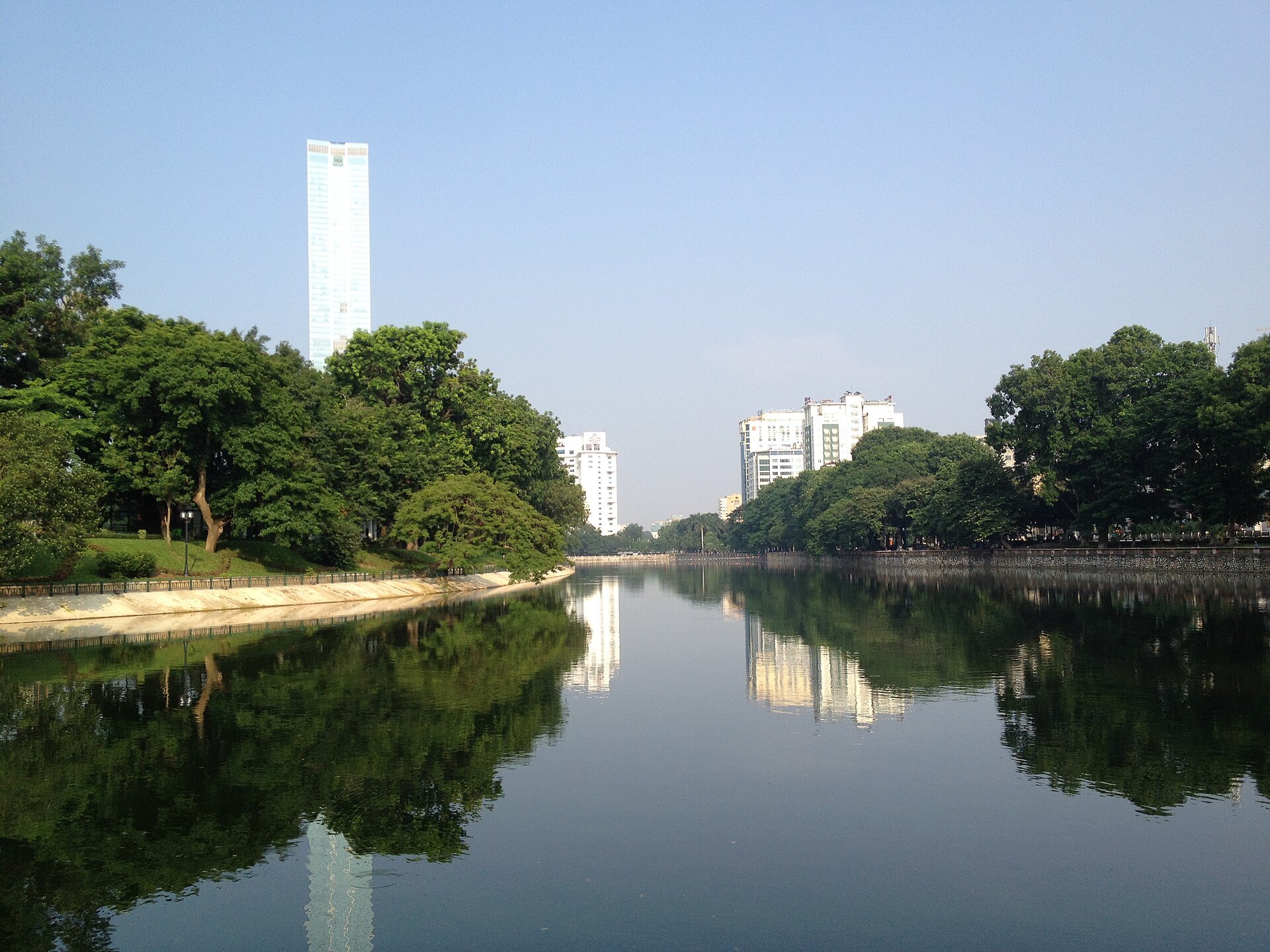 Một góc hồ Thủ Lệ với bờ kè và bóng cây quanh công viên.