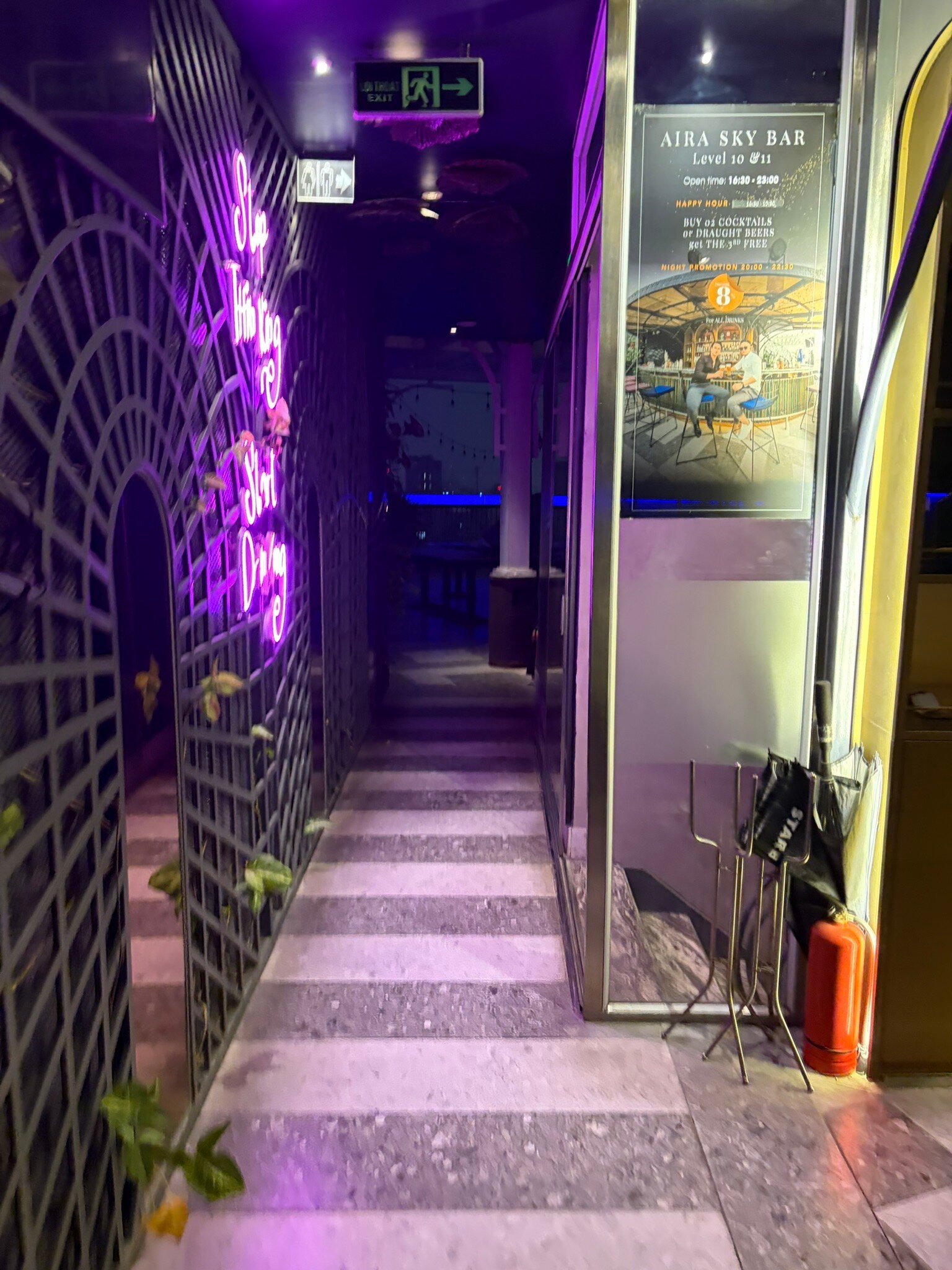 Hành lang lối vào AIRA Sky Bar & Lounge với tường lưới sắt và đèn neon tím