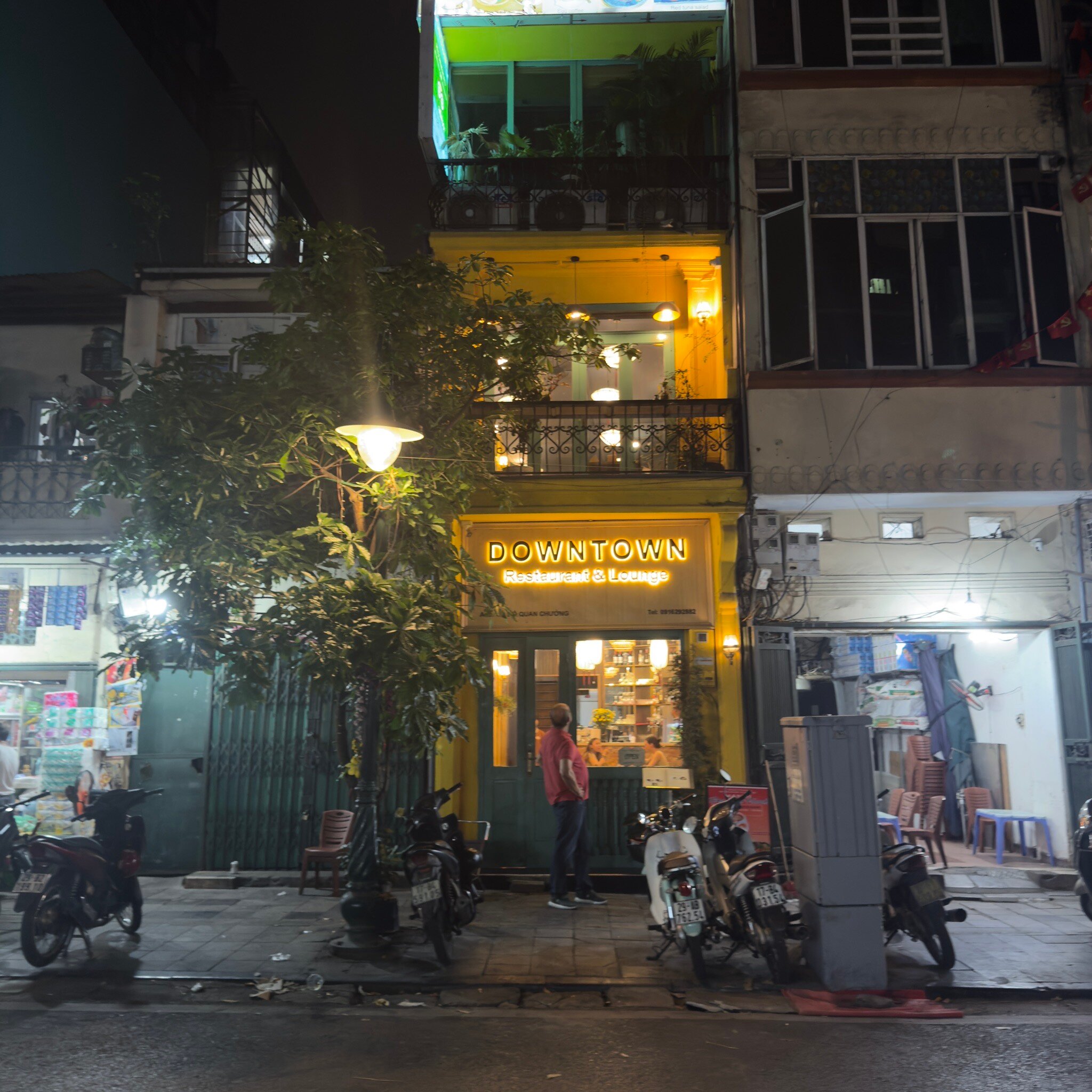 Mặt tiền nhà ống sơn vàng của Downtown Restaurant & Lounge trên phố Ô Quan Chưởng về đêm