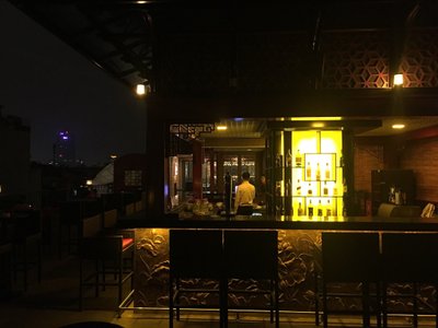 Quầy bar ngoài trời của MK Rooftop Bar & Restaurant sáng đèn vàng vào ban đêm