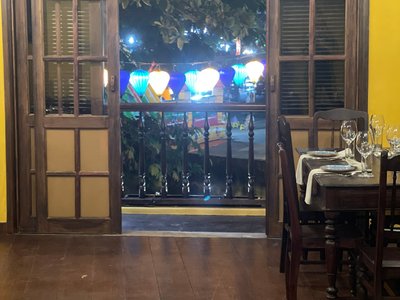 Bàn ăn cạnh cửa gỗ mở ra phố đèn lồng tại Ngói Vietnamese Cuisine