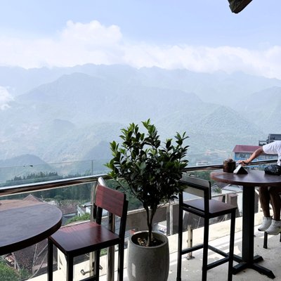 Bàn ghế cao trên sân thượng Sapa Sky View Restaurant & Bar nhìn ra núi phủ mây