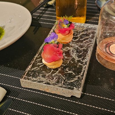 Món khai vị cá cuộn trên đế bánh, trang trí hoa violet tại Spices Villa