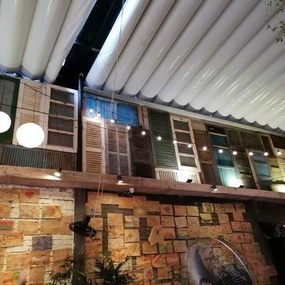 Dãy cửa chớp gỗ cũ nhiều màu trang trí vách quán The Rustic Kitchen & Chill Bar