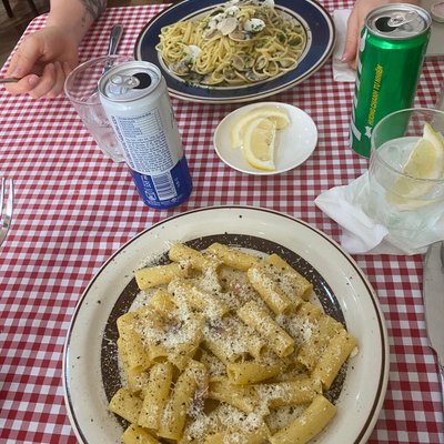 Rigatoni rắc phô mai và spaghetti nghêu trên bàn khăn caro tại Trattoria Da Stefano, Đà Nẵng