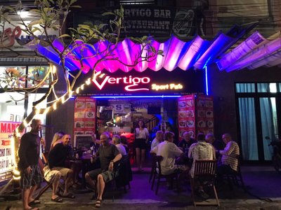Mặt tiền Vertigo Sport Pub ở Đà Nẵng với mái che đèn tím xanh và bàn ghế bên vỉa hè buổi tối
