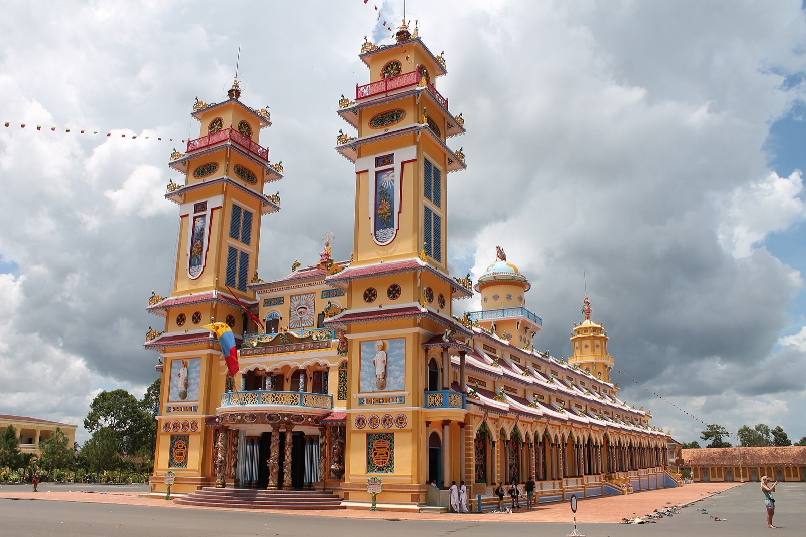 Mặt tiền Toà Thánh Cao Đài Tây Ninh với hai tháp chuông, tường vàng và mái đỏ.